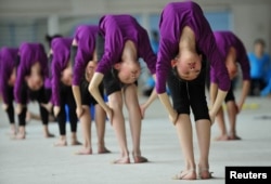 На занятиях по гимнастике в школе в китайском городе Шенян. 9 мая 2012 года.