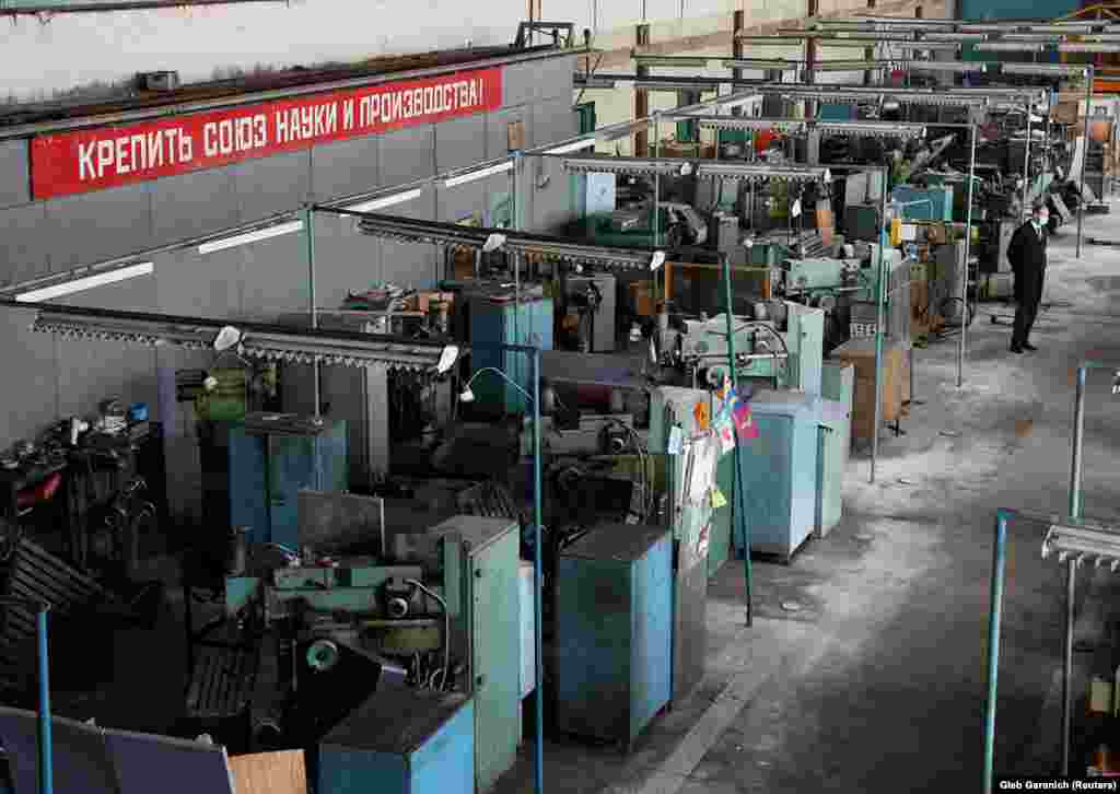 Виробничий цех заводу. Напис на стіні: &laquo;Зміцнювати союз науки і виробництва!&raquo;