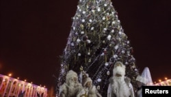 Жители Бишкека в костюмах Санты Клауса, Деда Мороза и Снегурочек у Новогодней ёлки.  