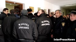 Грузинская полиция безопасности голосовала, прикрывая друг друга широкими спинами