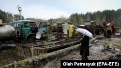 Չեռնոբիլ - կինը նայում է մեքենաներին, որոնց միջոցով լիկվիդացման աշխատանքներ են իրականացվել 1986-ի աղետի ժամանակ, 15-ը ապրիլի, 2021թ․