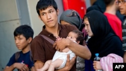 Семья мигрантов из Афганистана, прибывшая поездом из Будапешта, на вокзале Мюнхена. 31 августа 2015 года.