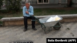 Етнічний албанець відпочиває біля графіті з написом «Бойкот перепису населення» у місті Буяновац на півдні Сербії 1 жовтня 2011 року