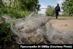Чоловік проходить повз оптоволоконний кабель, який залишився від російських FPV-дронів, що масово атакують Костянтинівку