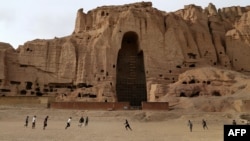 Афганские мальчики играют в футбол рядом со скалами, где стояли статуи Будды. Провинция Бамиан, февраль 2014 года.