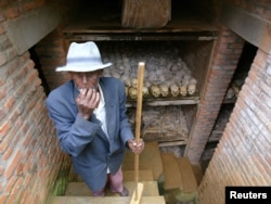 Руандийский рабочий проводит уборку братской могилы возле церкви в городе Ньянза, где захоронены неопознанные останки геноцида народа тутси, 2004 г.