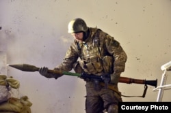 Боєць 74-го розвідбату «Рекс» заряджає гранатомет. Автор – Руслан Боровик