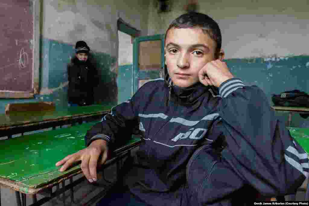 Армянский мальчик в полуразрушенном классе. Ученики и учителя ожидают, что грузинское правительство выполнит свое обещание помочь отремонтировать школу.