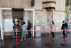 Кияни в захисних масках тримають дистанцію в черзі до ресторану «МакДональдс». Київ, 13 травня 2020 року