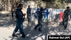 Поліцейський оглядає територію навколо Кабульського університету