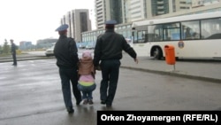 Полицейские несут на руках протестующую должницу по ипотеке в Астане. Иллюстративное фото. 