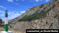 Өзбекстандын мамлекеттик желеги түшүрүлгөн мамы. Чек ара аймагына коюлган белги.