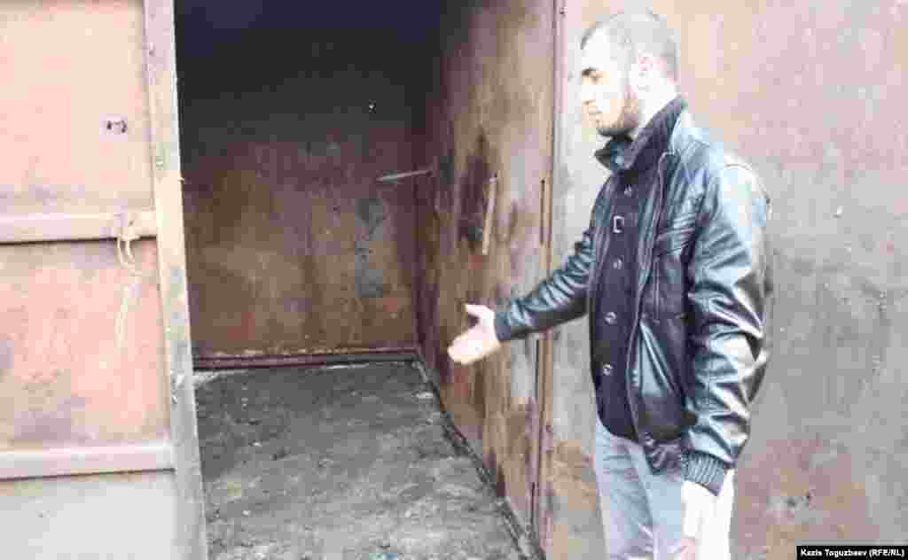 Погорелец Иззаджан Насымов показывает на железный контейнер, в котором, по его словам, руководители Турксибского района Алматы предлагают устроить кухню.