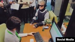 Dressed in an outfit vaguely reminiscent of Robocop, the former economy and trade minister glided through the flagship Sberbank branch in Moscow wearing special glasses, earmuffs, and body padding designed to impair his sight and hearing, and restrict his movement.