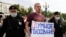 Russian police detain an opposition activist holding a poster featuring the Smart Voting logo during a protest in Moscow last month.