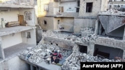 Мусульманська сім'я проводить іфтар в рамках священного місяця Рамадан на руїнах їх зруйнованого будинку, місто Аріху, провінція Ідліб. Травень 2020 року