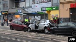 Співробітники екстрених служб працюють на місці події після того, як автомобіль (на фото червоного кольору) проїхав крізь групу пішоходів та виїхав на зустрічну смугу руху у Щецині. Польща, 1 березня 2024 року