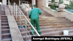 Работник перед зданием министерства труда Казахстана. Иллюстративное фото