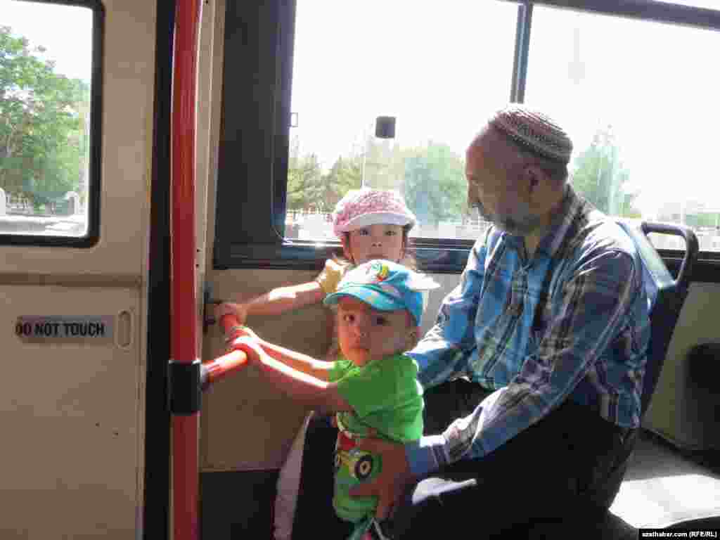 Aşgabadyň awtobuslarynyň birinde agtyklary bilen barýan ýaşuly.