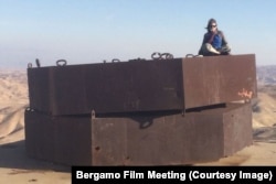 Шанталь Акерман рассказывает о своей жизни в фильме "Я ниоткуда", сидя на загадочном сооружении в пустыне