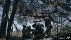 Ukrain esgerleri Donetsk sebitiniň Bahmut şäherindäki söweşde top okuny atýarlar. 3-nji maý, 2023 ý.
