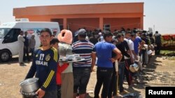 Turkey -- Displaced people from the minority Yezidi sect, fleeing violence in Iraq, line up to receive food as they take refuge in the southeastern Turkish town of Silopi, near the Turkish-Iraqi border crossing of Habur, August 13, 2014