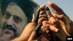 Предводителя иракских шиитов аль-Хакима (на плакате) пригласили в Белый дом после сокрушительного поражения партии Буша на выборах в конгресс