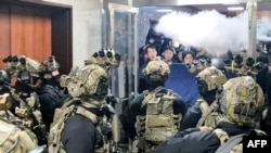 Президент өзгөчө абал жарыялагандан кийин аскерлер парламенттин имаратына кирүүгө аракет кылып жатышкан учур. 3-декабрь, 2024-жыл. 
