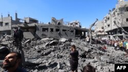 Palestinians inspect the damage after an Israeli strike in the Al-Bureij camp in the central Gaza Strip on July 4, 2025.
