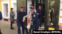 Полиция задерживает Бакизу Халелову, участницу митинга с требованием «освободить политзаключенных». Уральск, 10 мая 2018 года.
