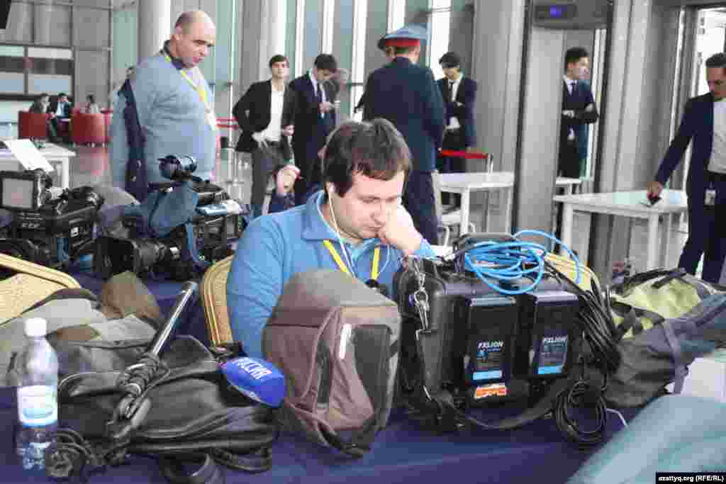 Российский журналист проверяет технику перед началом переговоров.