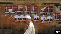 Мужчина идет мимо предвыборных плакатов кандидатов в президенты. Каир, 18 мая 2012 года.