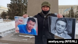A activist holds up photos of Dulat Agadil (left) and his son Zhanbolat.