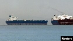 Мальтанын желеги астында жүргөн "Delvar" танкери (солдо) Сингапурга Ирандан мунай алып келип, жээкке токтоп жаткан учуру. Март, 2012