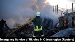 Рятувальник гасить пожежу після російської атаки на Одесу 17 листопада 2024 року