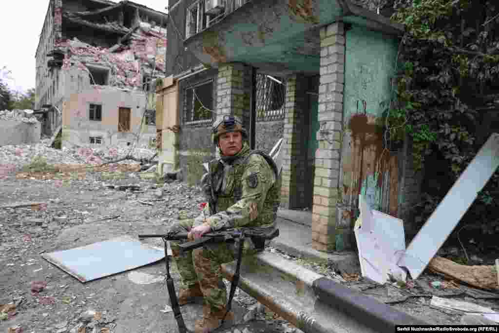 Пресофіцер 93 бригади «Холодний Яр» Максим Бондаренко слідкує за небом, щоб у випадку появи дронів збити їх, поки журналісти спілкуються з цивільними 