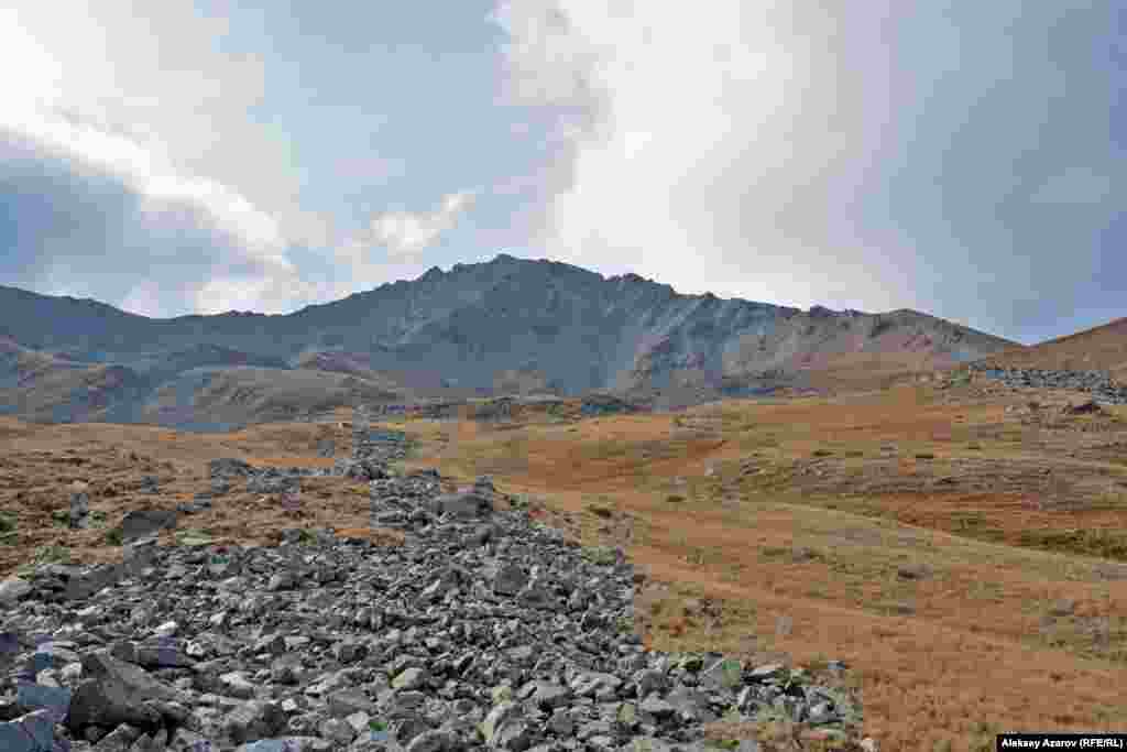 На этом фото &ndash; долина ниже Кыземшека. На камнях, которые тянутся вниз полосами, множество наскальных рисунков, датируемых эпохами бронзы, раннего железного века и первыми десятью веками нашей эры. Считается, что скопление петроглифов в этом районе Казахстана обнаружила 20 августа 2010 года группа туристов из пяти человек.