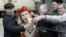 Активистка группы Femen пытается выхватить микрофон во время пророссийского митинга в Симферополе