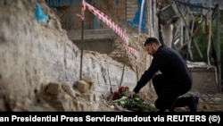 President Volodymyr Zelenskiy pays his respects to those were were killed when part of a Kyiv apartment block collapsed during a massive Russian drone and missile attack on the Ukrainian capital on July 17. 