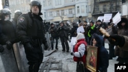 Демонстрант аялдар полиция алдында чөгөлөөдө. 24-январь, 2014.