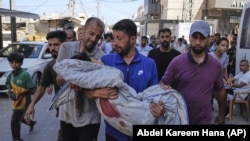 Сваякі нясуць цела 13-гадовага падлетка, які загінуў у выніку пападаньня ўдару ізраільскай арміі ў пункт раздачы пітной вады ў лягеры для ўцекачоў, 13 ліпеня 2025 году