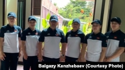 Кыз-келиндер күрөшү боюнча Кыргызстандын жаштар курама командасынын мүчөлөрү өлкөнүн күрөш федерациясынын вице-президенти Байгазы Кенжебаев менен. 11-июль, 2019-ж. Таиланд.