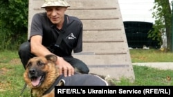 Former Ukrainian solder Vasyl Velychko pets Ira, one of his many wards at a dog shelter in Lviv, western Ukraine.