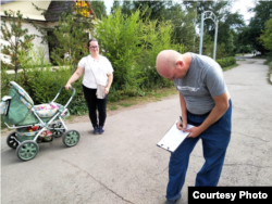 Житель Щучинска ставит подпись против застройки городского парка. Акмолинская область, 5 августа 2021 года
