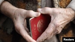 Пожилая женщина держит в руках советский паспорт. Иллюстративное фото.