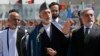 Afghan President Hamid Karzai (center) speaks during celebrations to commemorate Afghanistan's 95th anniversary of independence as he is flanked by presidential candidates Abdullah Abdullah (right) and Ashraf Ghani in Kabul on August 19.