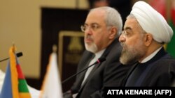 Иран президенти Хасан Роухани (оңдо) жана өлкөнүн тышкы иштер министри Зариф