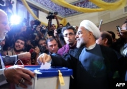 Президенттікке кандидат Хасан Рохани (оң жақта) сайлауда дауыс беріп тұр. Тегеран, 14 маусым 2013 жыл.