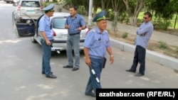 Ýol polisiýasynyň ofiseri ulag eýesiniň 'düşündirişini' diňleýär. Arhiw suraty