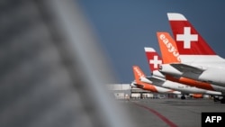 Коммерческие самолеты лоукостеров EasyJet и дочерней авиакомпании Lufthansa Swiss припаркованы из-за прерывания полетов на фоне распространения COVID-19 в аэропорту Женевы. 3 апреля 2020 года